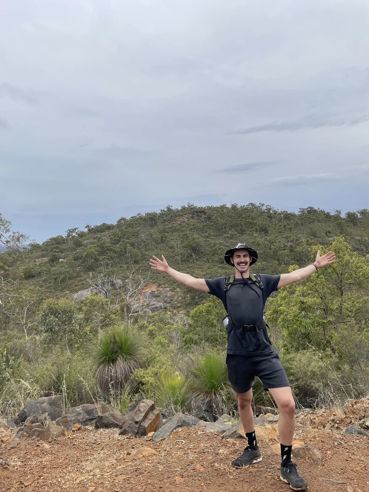 Lennox with arms spread wide on a bush trail in John Forrest National Park, Perth hills