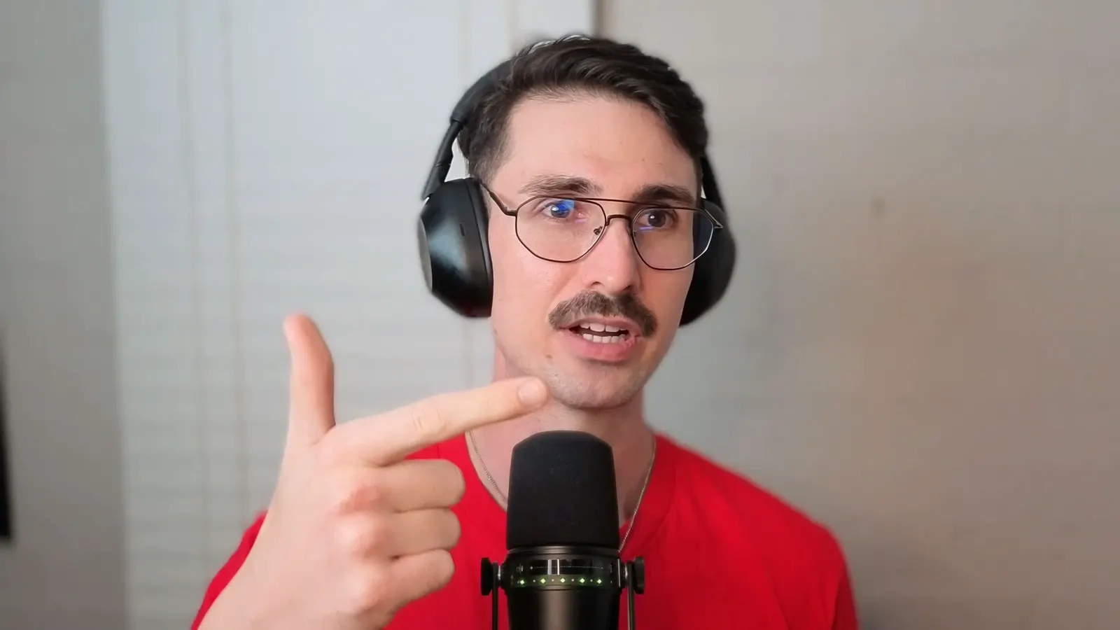 Lennox at the microphone in headphones, pointing toward the camera